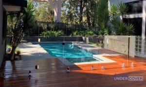 Elegant Patio with Wooden Deck and Pool — Pool Cover Systems in Nowra, NSW
