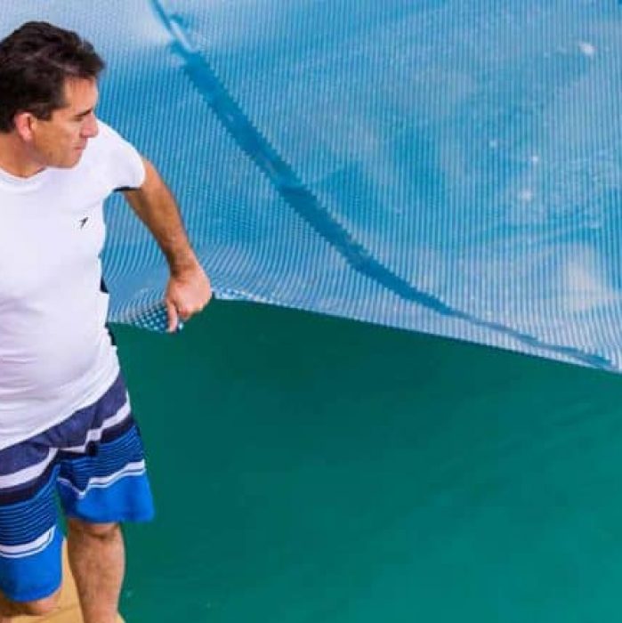 Guy by Pool Under Blue Tarp — Pool Cover Systems in Nowra, NSW